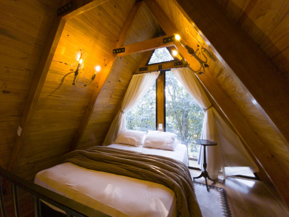 Cama king no mezanino de madeira da Cabana Kaiapó